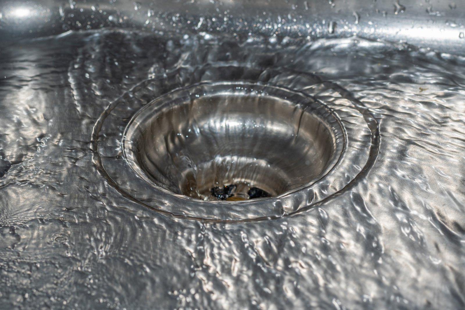 Water drain in silver sink - flowing water