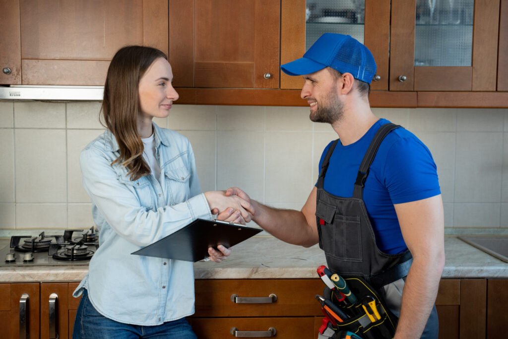 Customer woman signing invoice from male plumber standing in kitchen